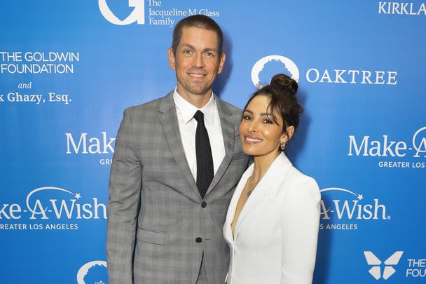 Steve Howey and Sarah Shahi posing for a photo at an event.