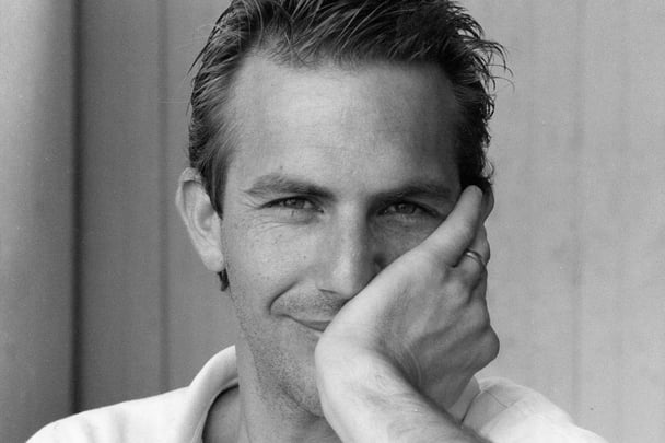 A black and white photo of Kevin Costner in 1985.
