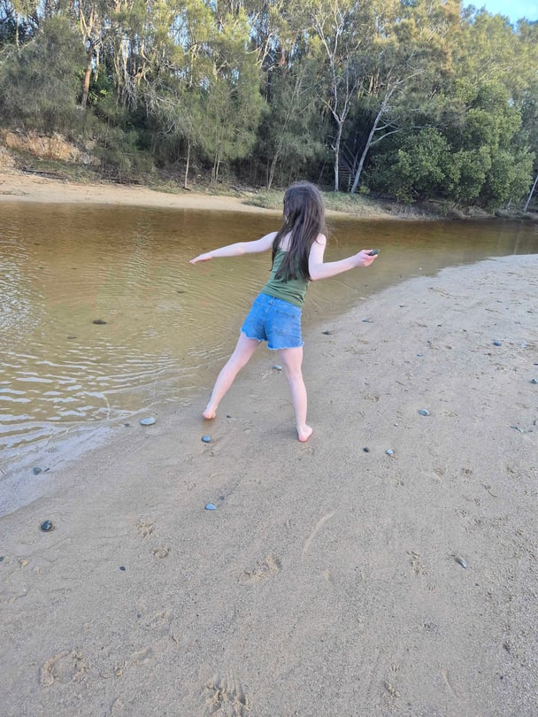 Child exploring creekside nature trail near Coffs Harbour.