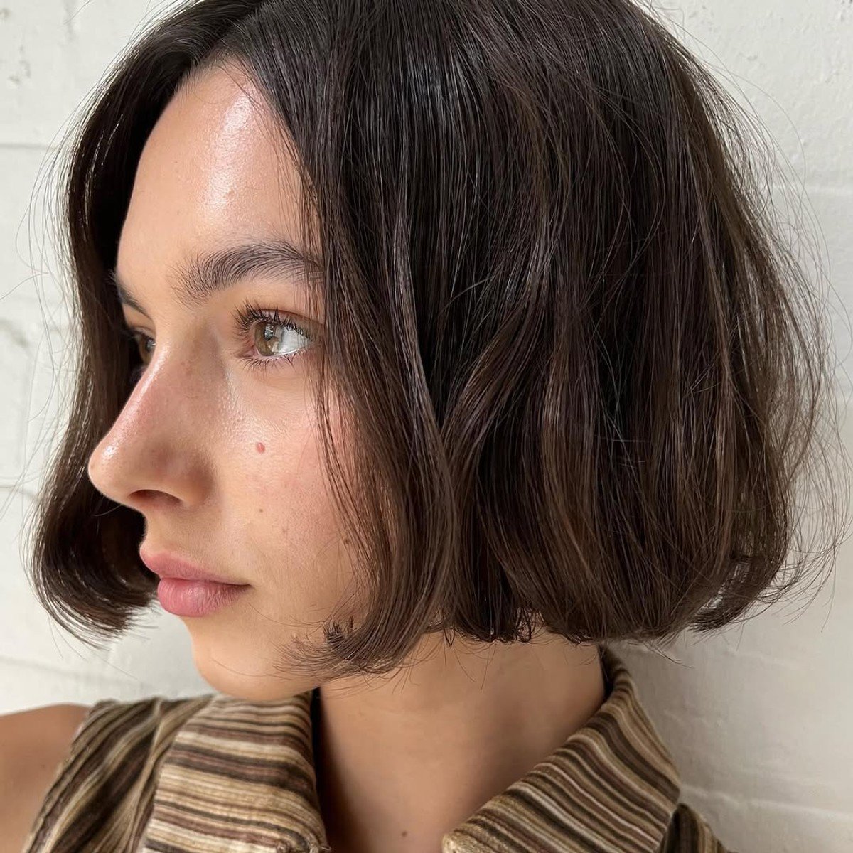 A picture of a woman with a chin-grazing brunette bob.