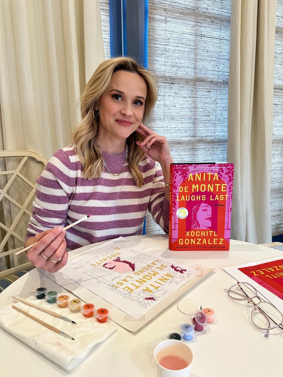 Reese Witherspoon painting a book cover.