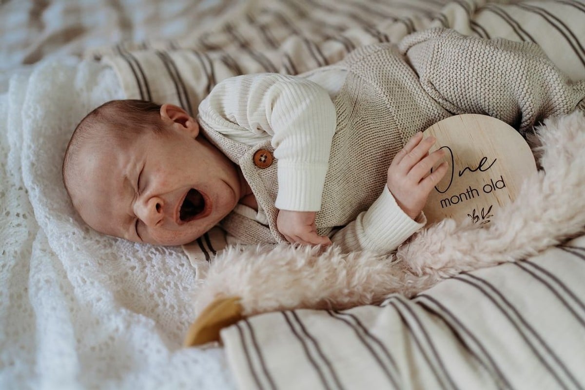 A one-month-old baby boy yawning.