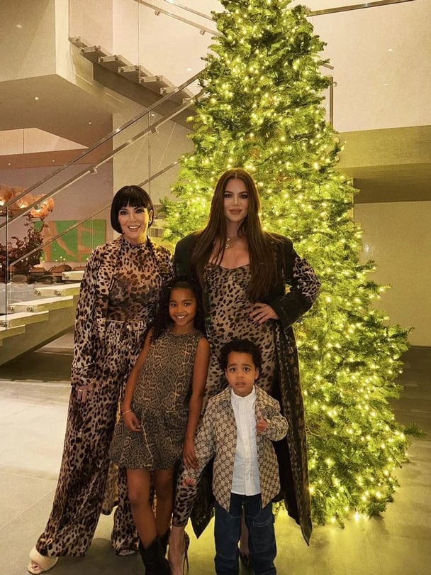 Khloe Kardashian, Kris Jenner, and her two children, True and Tatum Thompson,in front of her huge Christmas tree