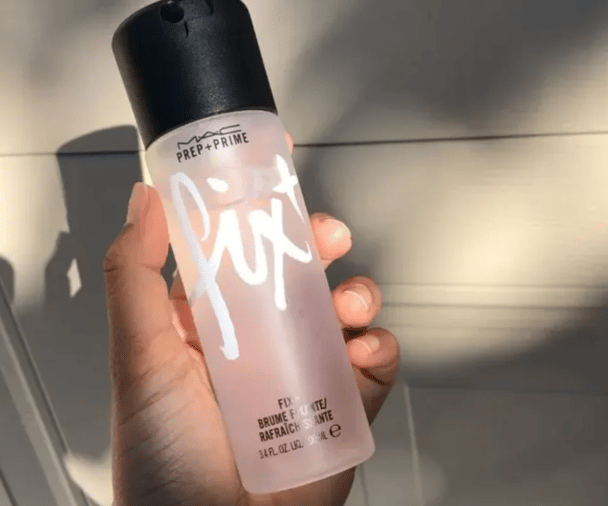 Woman's hand holding MAC Prep + Prime Fix+ spray.