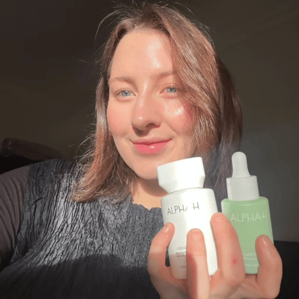 Woman holding Alpha H skincare products.