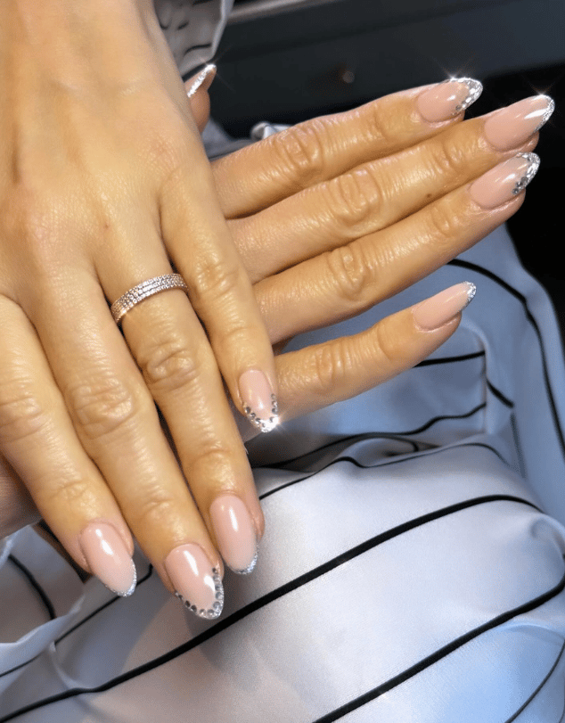 French manicure with silver jewels on the tips of nails, shaped in a nail crown design