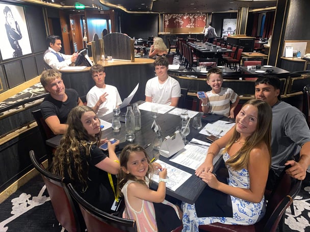 The kids and teens sit for a meal at a table. Image: Supplied.