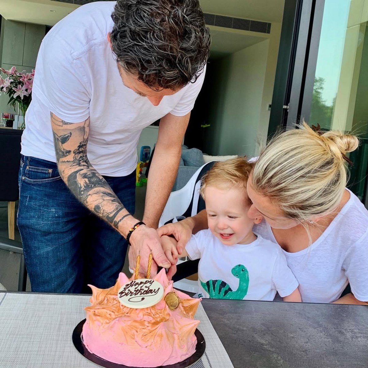 Jock and Lauren Zonfrillo cutting a birthday cake for one of their children. 