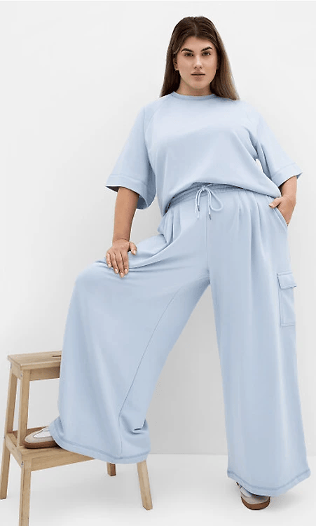 woman wearing sweat top and track pants in powder blue from city chic