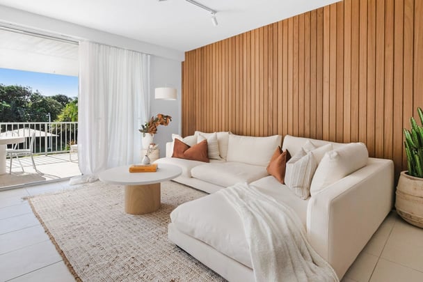 A lounge room looking out to a balcony and pool.