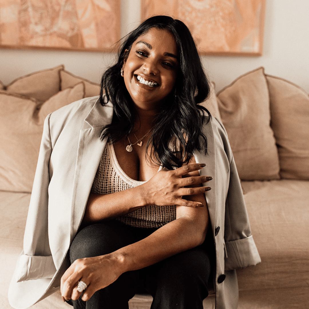 Psychologist Anoushka Dowling headshot smiling on couch.