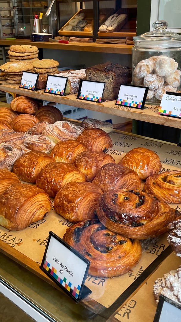 A display cabinet of pastries including croissants and custard snails.