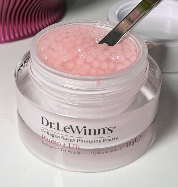 A close up of the open jar of Dr LeWinn's Collagen Surge Plumping Pearls, where the pink gel-like pearls are full to the top.
