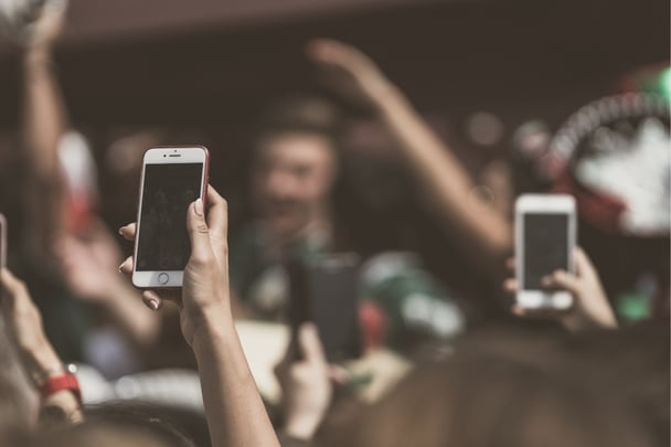 Crowd holding up phones.