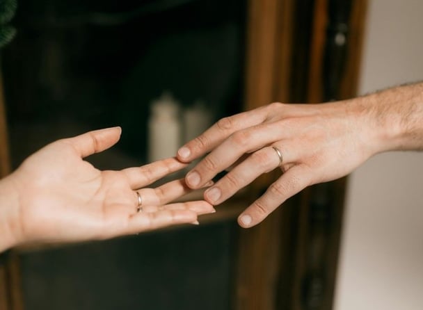 Two hands reaching for one another.