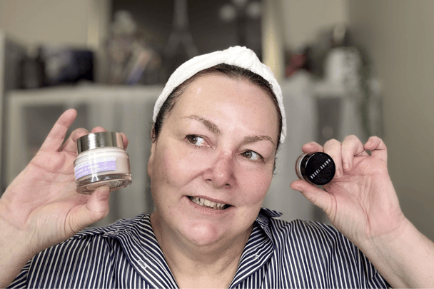 A woman holds up two primers side-by-side next to her face.