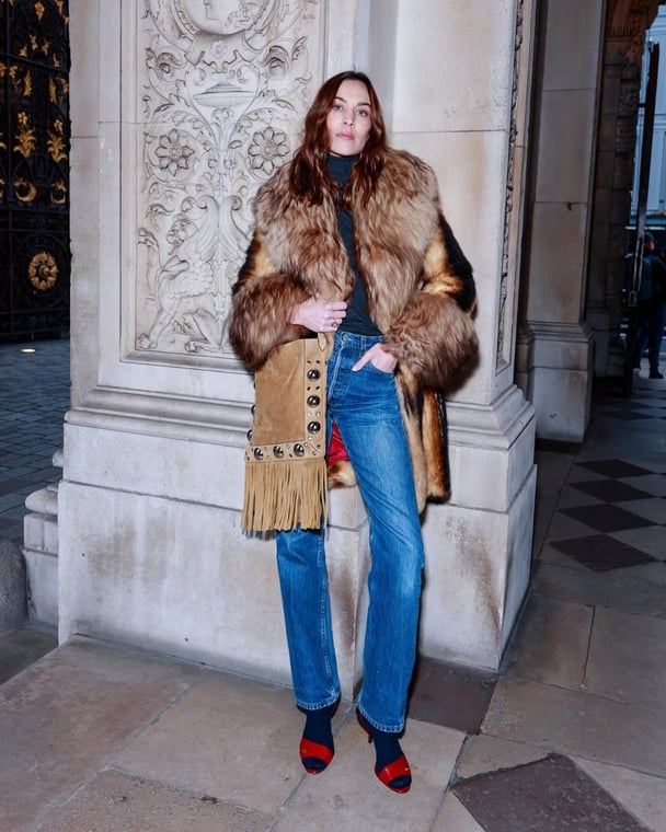 Alexa Chung wears blue straight-leg jeans with a Valentino outfit.
