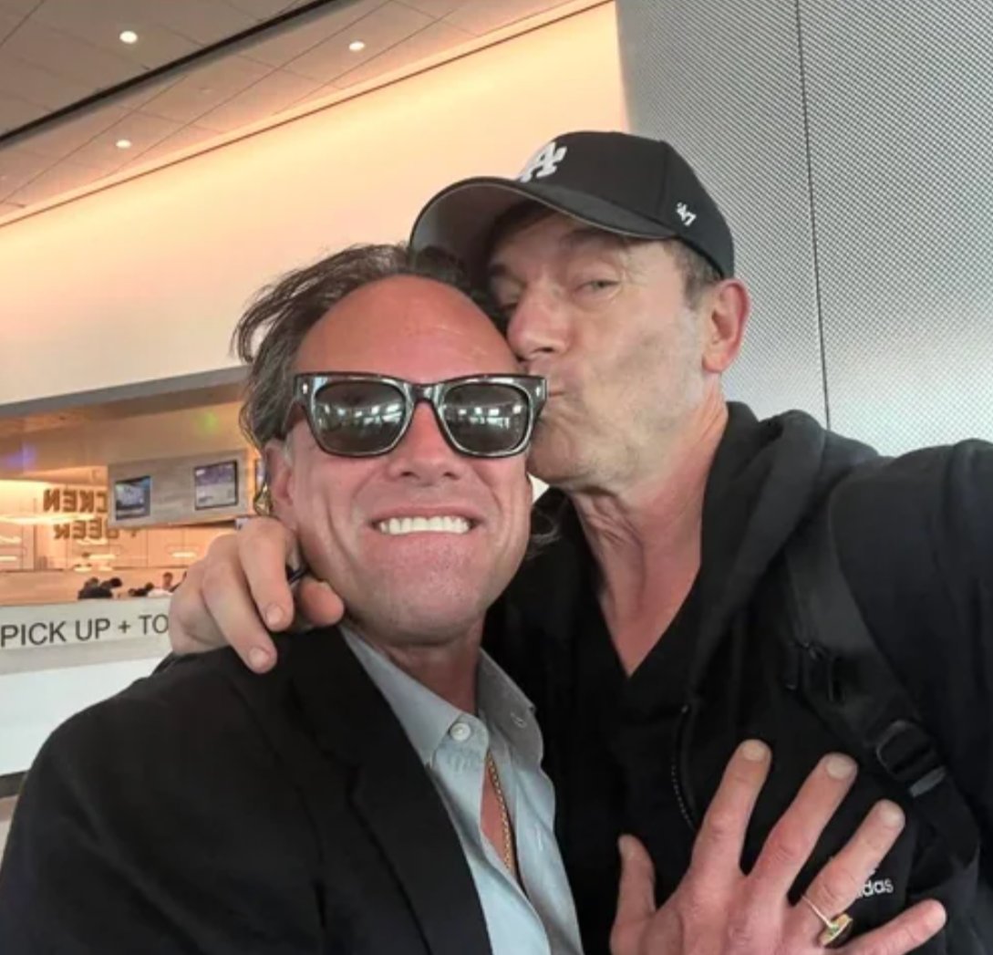 Walton Goggins and Jason Isaacs take an airport selfie together.