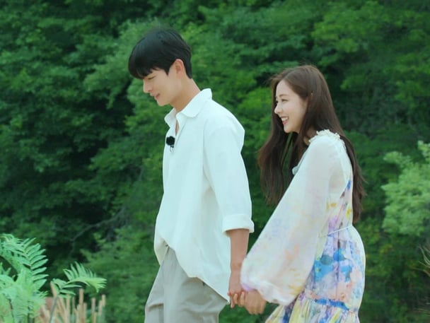 Two contestants from Single's Inferno holding hands.