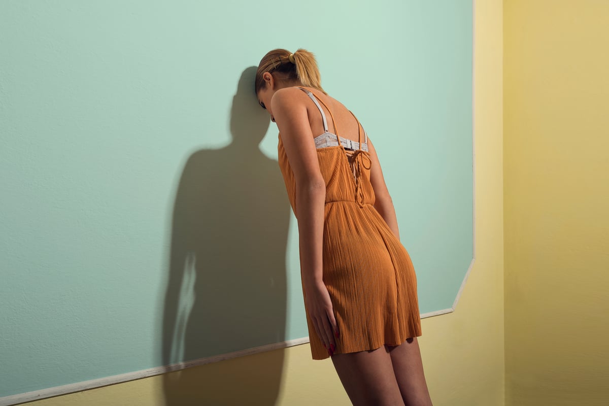 woman butting head against a wall