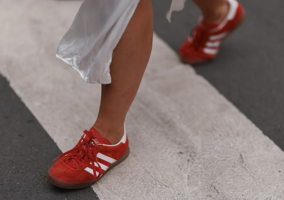 Red Adidas Samba trainers pictured on a woman crossing the street.