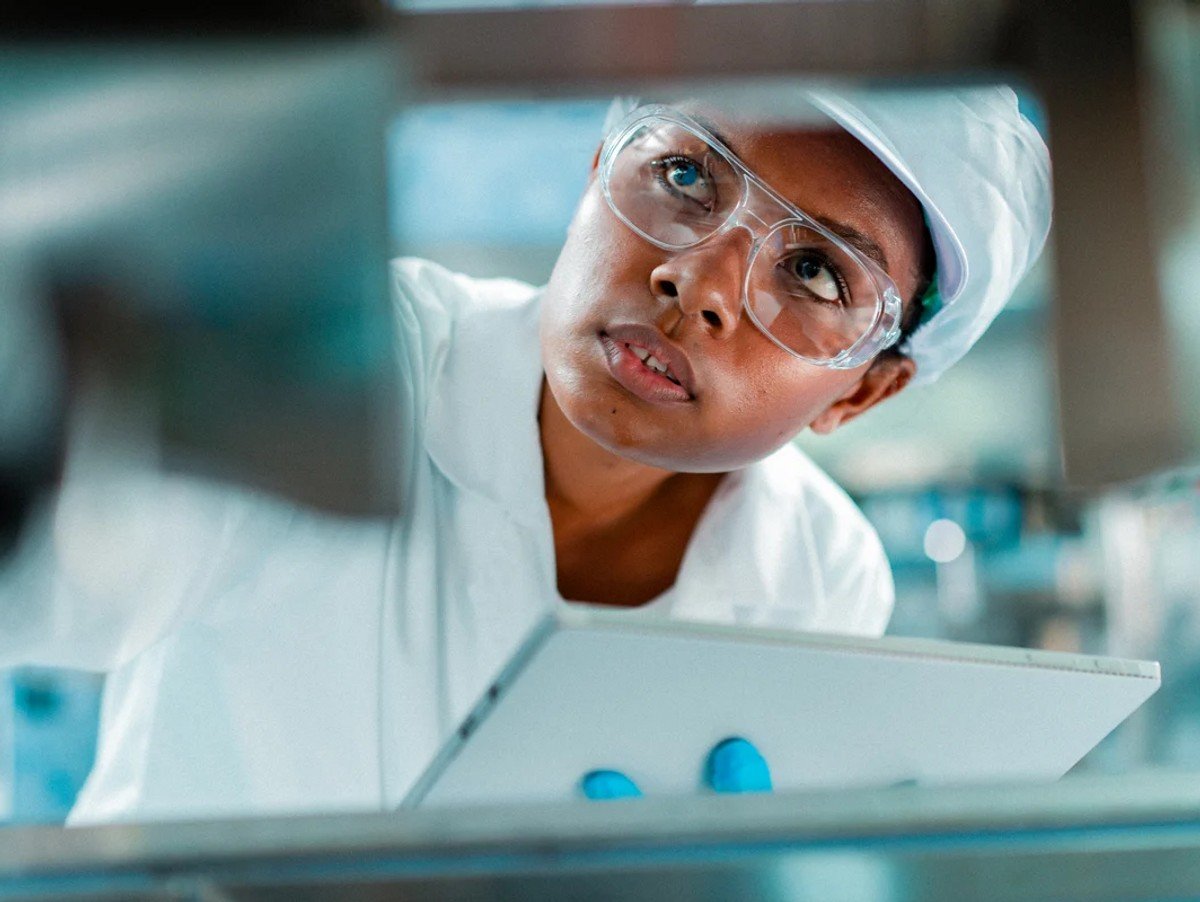 Female engineer in a drinking water factory in professional uniform using digital tablet working in beverage industrial. 