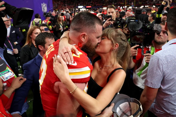 Travis Kelce kisses Taylor Swift after SuperBowl win.