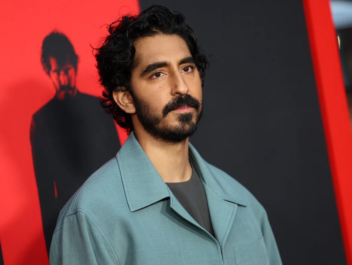 Dev Patel attends the Los Angeles premiere of Universal Pictures' Monkey Man, standing in front of a poster for the movie.