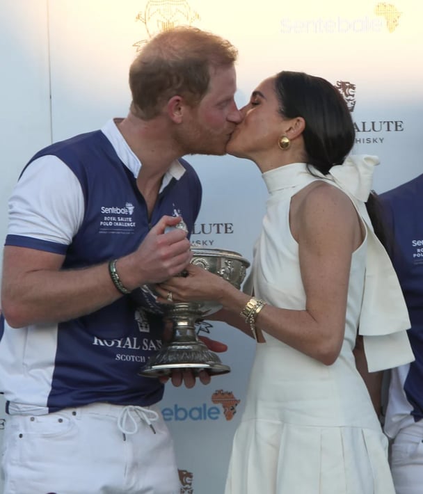 The Duchess of Sussex presents a trophy to her husband, the Duke of Sussex.