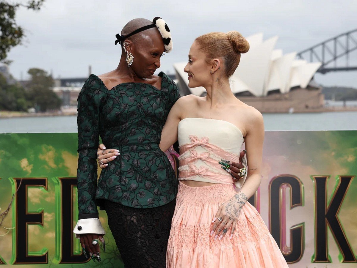 Cynthia Erivo and Ariana Grande posing for photos in front of Harbour Bridge in Australia