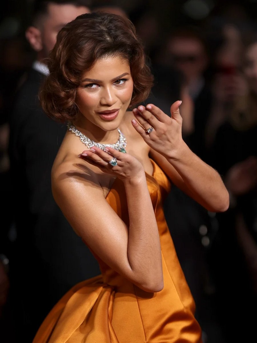 Zendaya wears an orange gown and attends the 82nd Annual Golden Globe Awards at The Beverly Hilton.