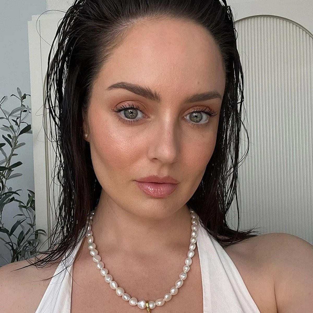 Beauty content creator Chloe Morello posting for a picture with glowing skin.