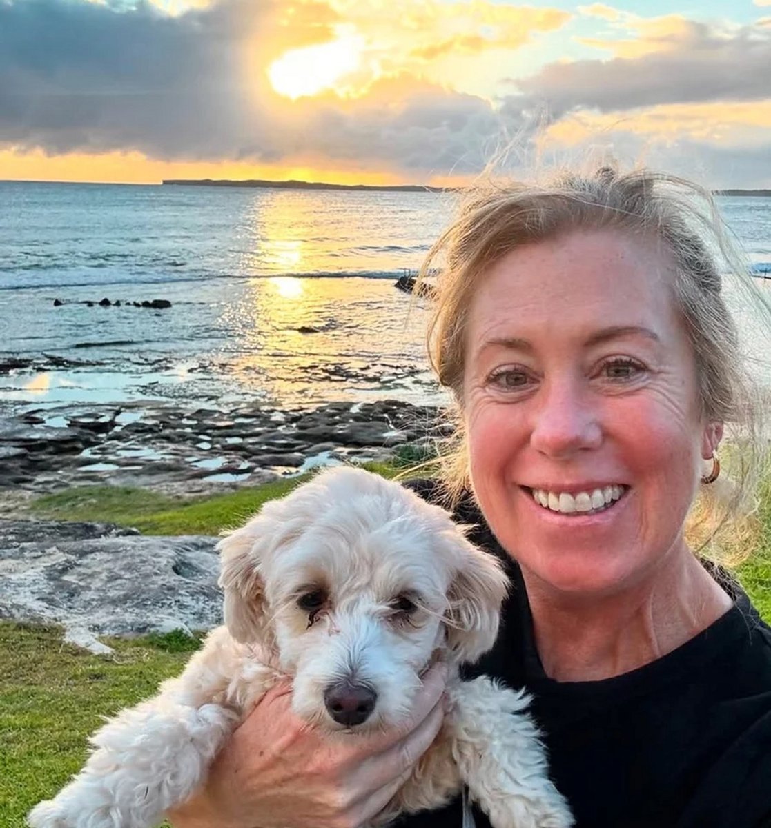 Image of Evie smiling whilst holding dog
