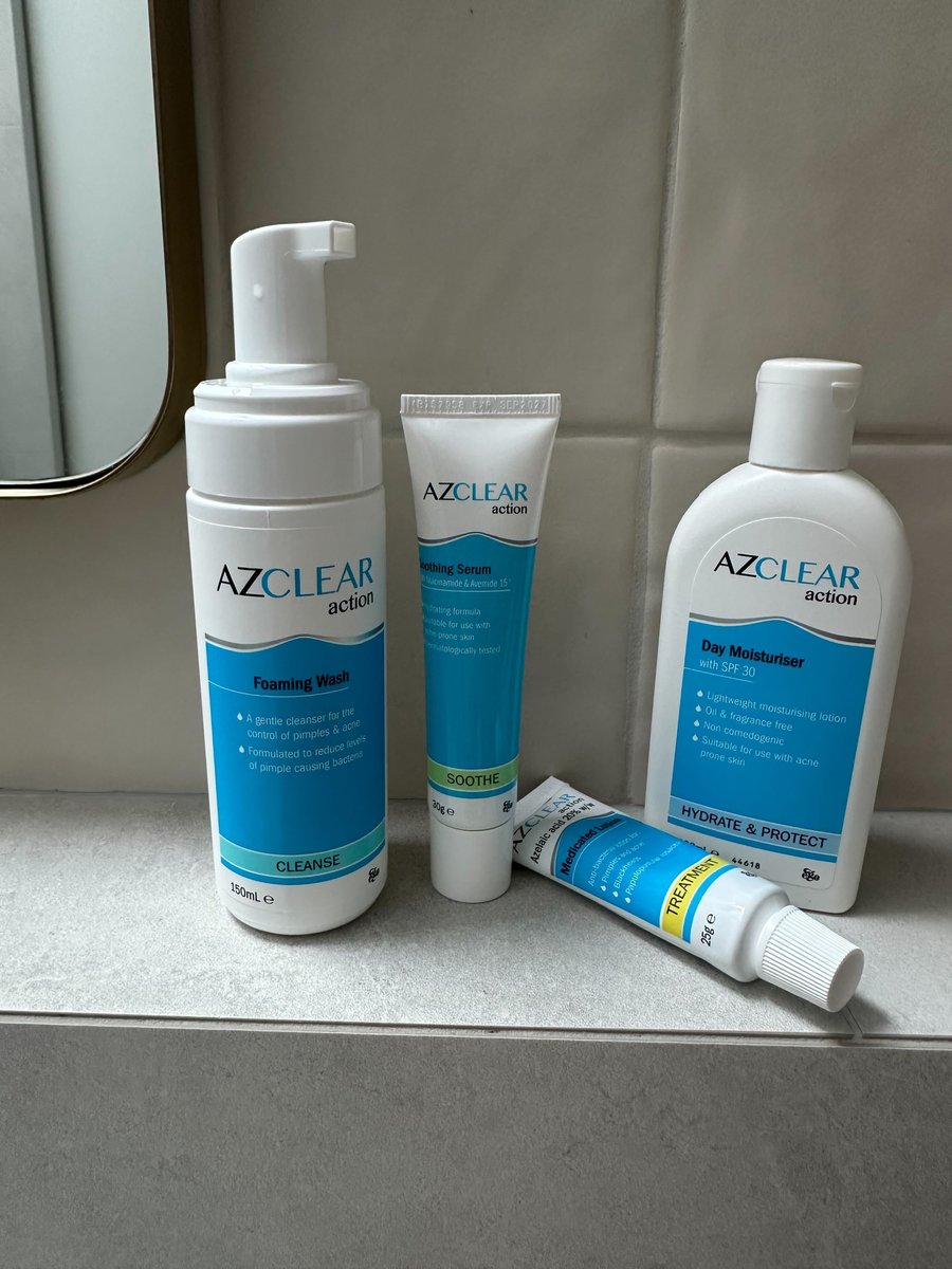 Azclear range of products pictured in a bathroom, including the Foaming Wash, Soothing Serum Day Moisturiser and Medicated Lotion.