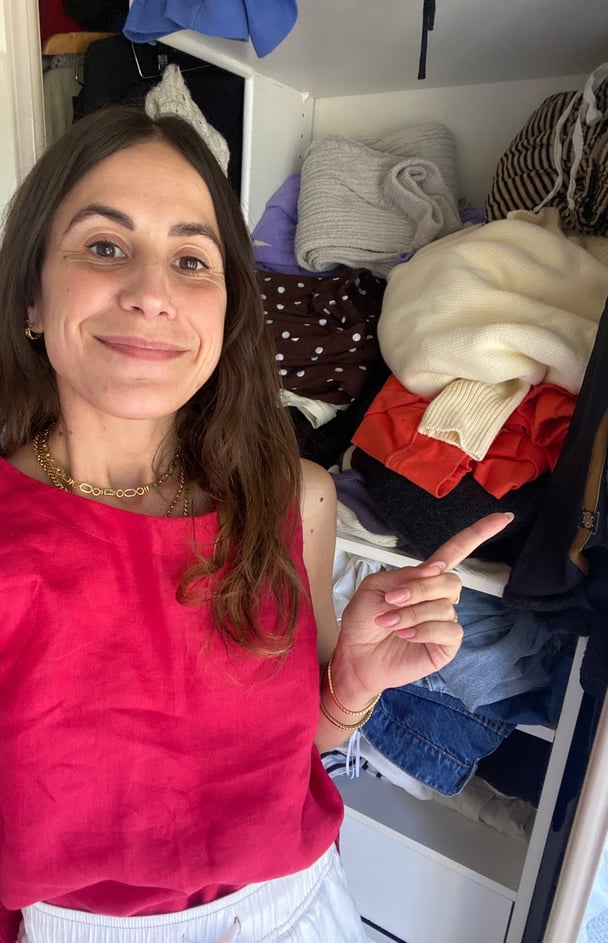 Writer shares a look at her closet, which is full of piles of clothes.