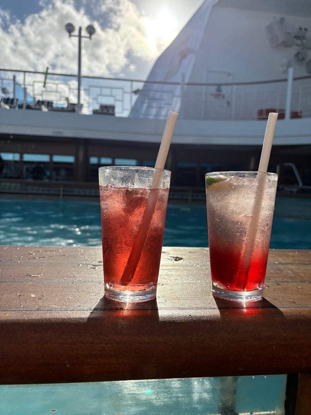 A picture of drinks by a pool on a Carnival Cruise ship.