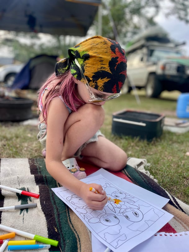 a girl colouring a pokemon colouring page at the park