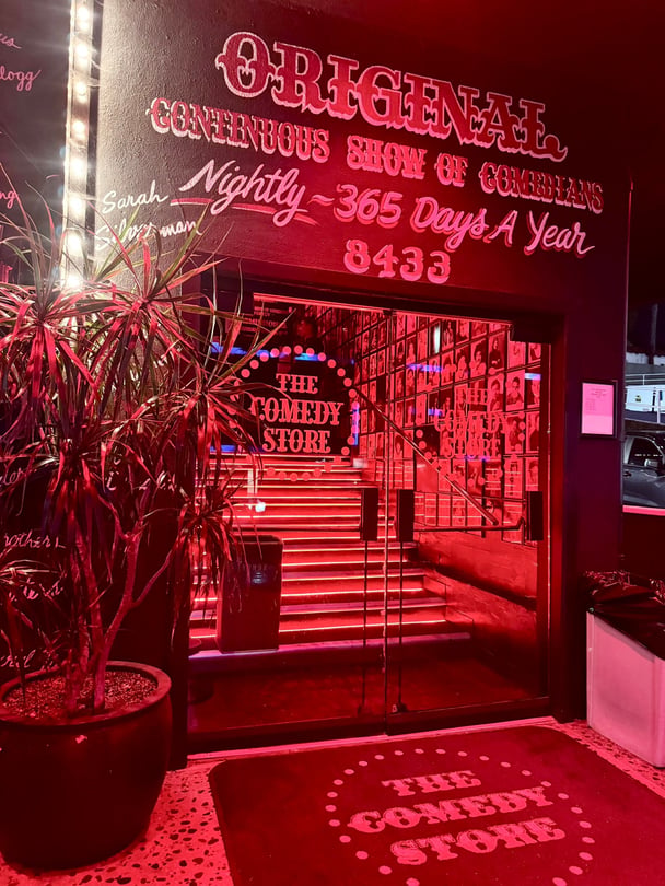 The entrance of the Comedy Store in red lighting. 