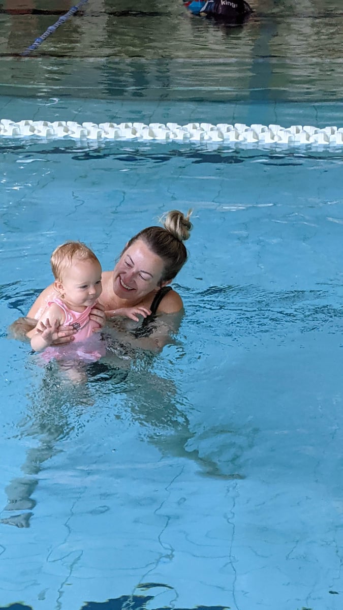 A mother teaching her baby to swim during early childhood swimming lessons.