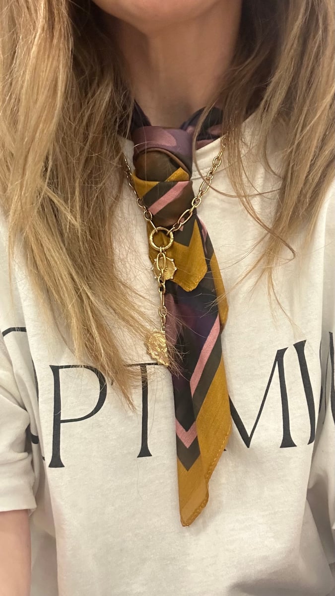 Author wears a scarf around her neck.