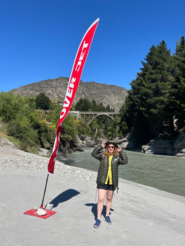 A woman standing by a lake to start jet boating.