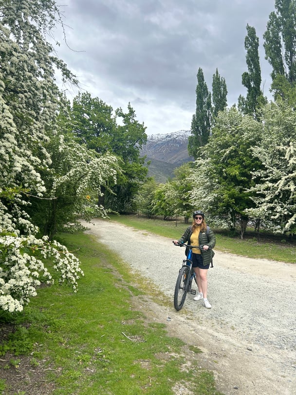 Woman smiling on a bike on the trail at Arrowtown. 