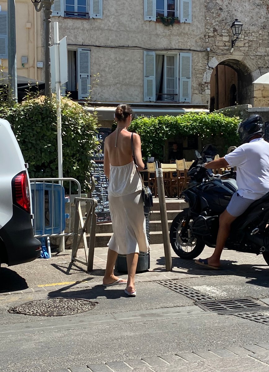  In Antibes, a stylish woman dresses down her outfit with white thongs.