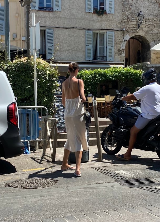  In Antibes, a stylish woman dresses down her outfit with white thongs.
