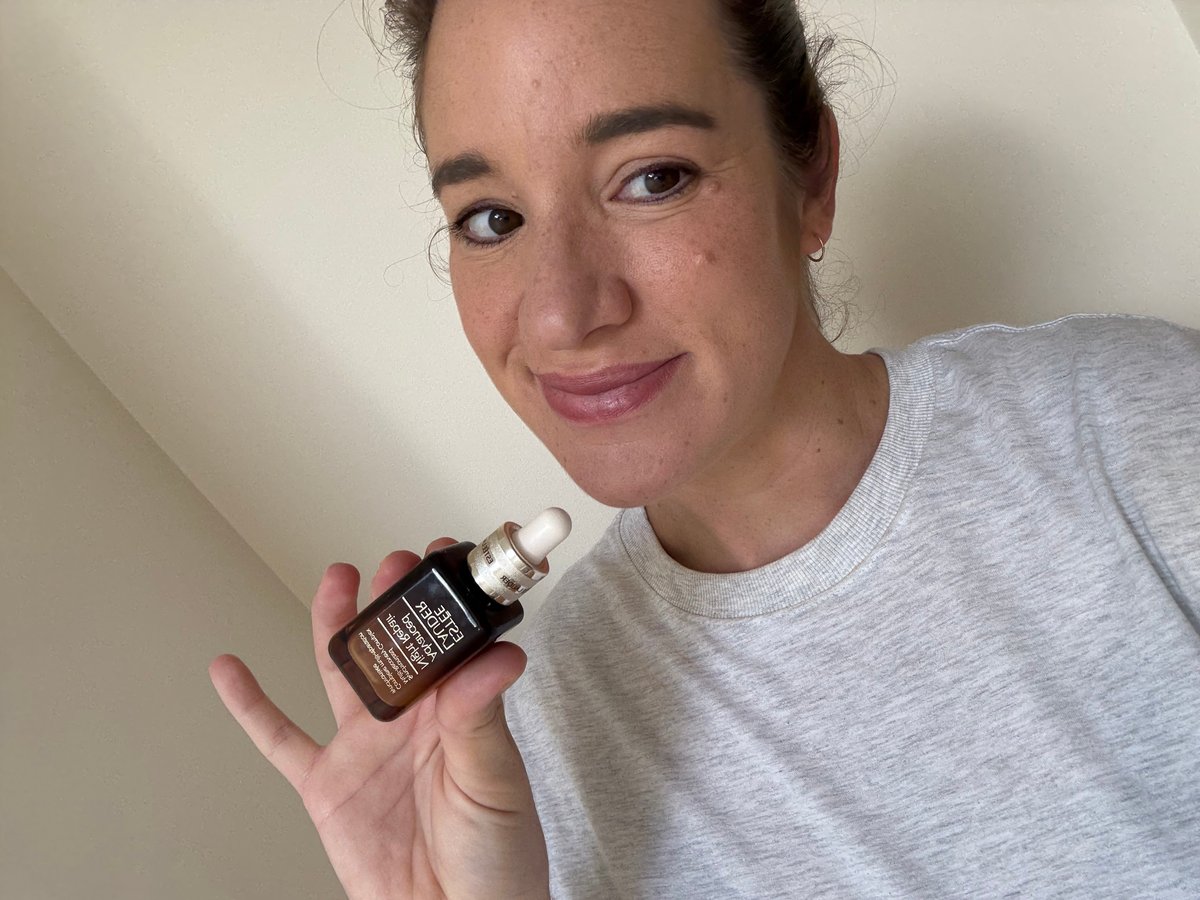 A beautiful woman holding up a bottle of Estee Lauder's Advanced Night Repair Synchronised Multi-Recovery Complex..