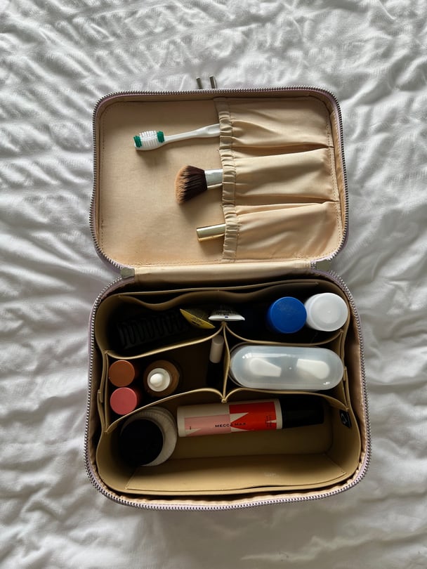 A top-down view of beauty products in a travel bag.