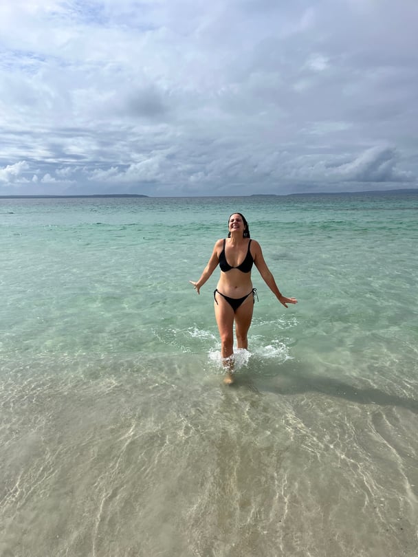 A woman poses in a serene beach.
