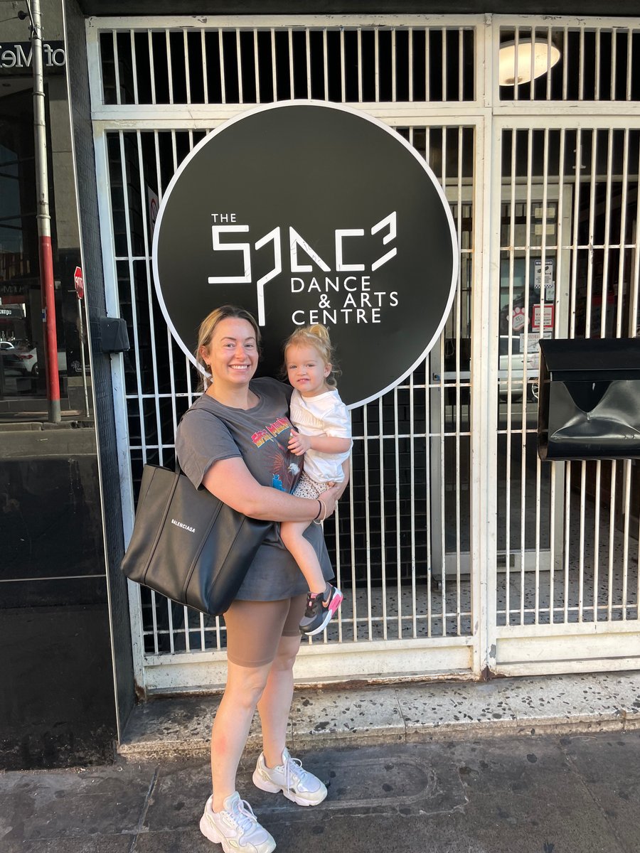 A mother and daughter outside a dance and arts centre for kids' extracurricular activities.