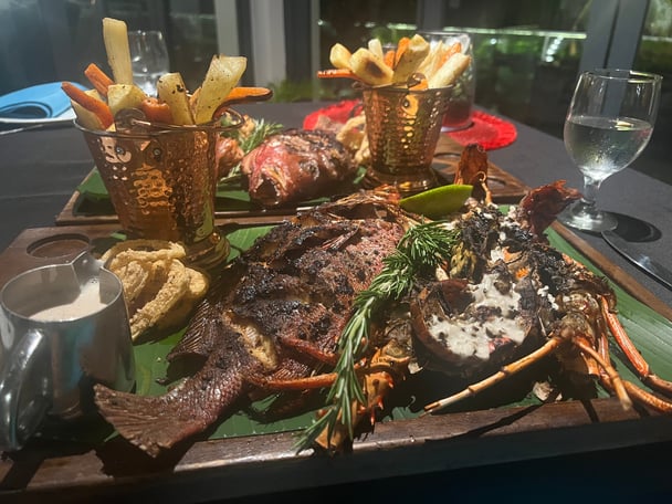 two platters of grilled snapper and chips on a table