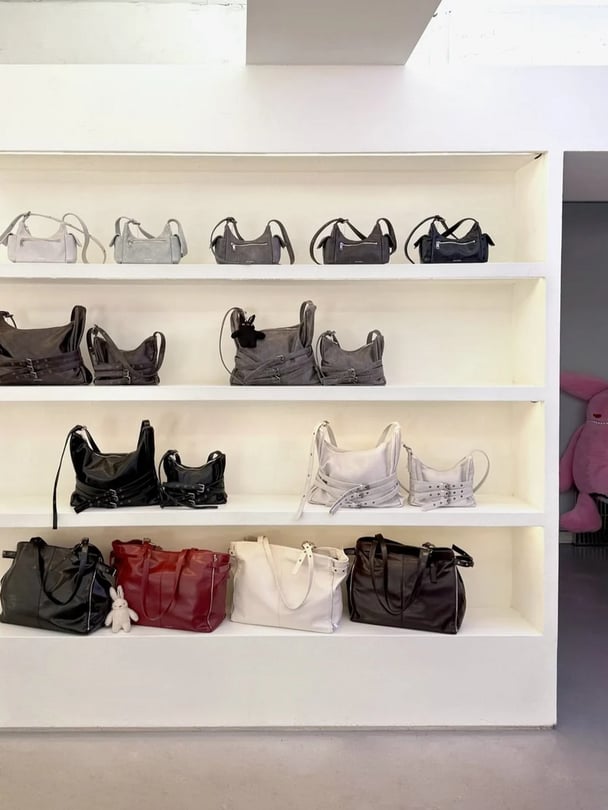 A shelf of different coloured bags.
